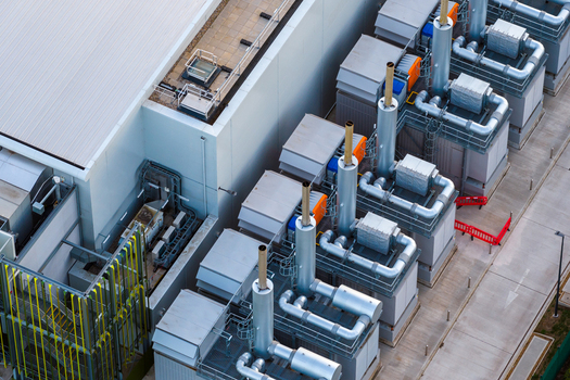 Aerial view of the Kao Data facility featuring industrial cooling units and ventilation pipes on the roof in Harlow England United Kingdom. Aerial view of the Kao Data facility featuring industrial cooling units and ventilation pipes on the roof in Harlow England United Kingdom.