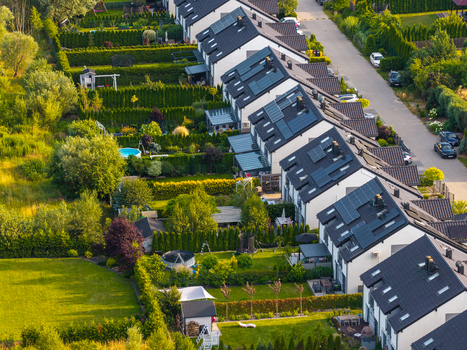 Aerial view of modern residential houses with solar panels on rooftops lush green gardens and trees in a suburban neighborhood in Kowale Pomeranian Voivodeshi Poland. Aerial view of modern residential houses with solar panels on rooftops lush green gardens and trees in a suburban neighborhood in Kowale Pomeranian Voivodeshi Poland.