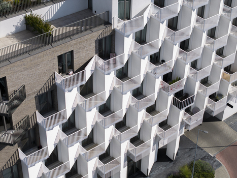 Aerial view of modern building facade with geometric white balconies and brick textures in Krakow Lesser Poland Poland.
