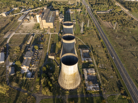 Aerial view of the abandoned Inota Power Plant cooling towers surrounded by industrial structures overgrown vegetation and nearby roads in Varpalota Hungary. Aerial view of the abandoned Inota Power Plant cooling towers surrounded by industrial structures overgrown vegetation and nearby roads in Varpalota Hungary.