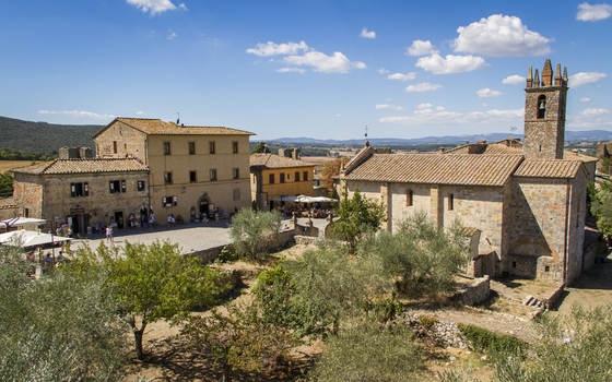 View of ancient stone buildings bask in the Tuscan sun framed by olive trees and clear skies a timeless scene of history and beauty in Monteriggioni Tuscany Italy. View of ancient stone buildings bask in the Tuscan sun framed by olive trees and clear skies a timeless scene of history and beauty in Monteriggioni Tuscany Italy.