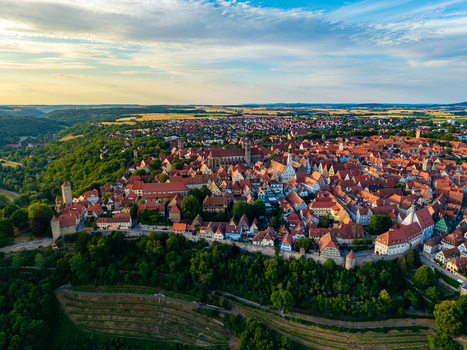 Aerial view of the historic town featuring medieval architecture red tiled rooftops and surrounding lush greenery in Rothenburg ob der Tauber Bavaria Germany. Aerial view of the historic town featuring medieval architecture red tiled rooftops and surrounding lush greenery in Rothenburg ob der Tauber Bavaria Germany.