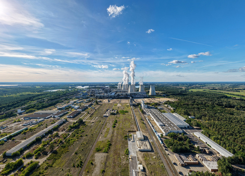 Aerial view of the Janschwalde Power Station with its cooling towers emitting steam surrounded by industrial infrastructure and forests in Peitz Brandenburg Germany. Aerial view of the Janschwalde Power Station with its cooling towers emitting steam surrounded by industrial infrastructure and forests in Peitz Brandenburg Germany.
