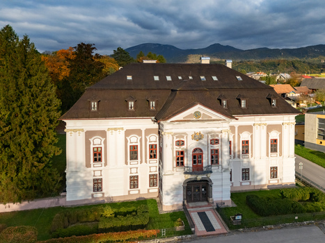 Aerial view of the grand Mosovce manor house its bright facade contrasting its dark roof amidst autumn trees and green lawns Mosovce Zilina Region Slovakia. Aerial view of the grand Mosovce manor house its bright facade contrasting its dark roof amidst autumn trees and green lawns Mosovce Zilina Region Slovakia.