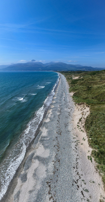 Aerial view of the coastline and sandy beach with the Mourne Mountains in the background near Newcastle Northern Ireland United Kingdom. Aerial view of the coastline and sandy beach with the Mourne Mountains in the background near Newcastle Northern Ireland United Kingdom.