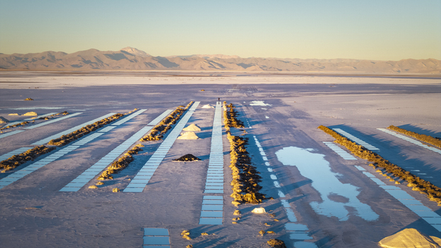 Aerial view of Salinas Grandes salt flats featuring geometric extraction pools and salt mounds under a clear sky in La Poma Department Salta Province Argentina. Aerial view of Salinas Grandes salt flats featuring geometric extraction pools and salt mounds under a clear sky in La Poma Department Salta Province Argentina.