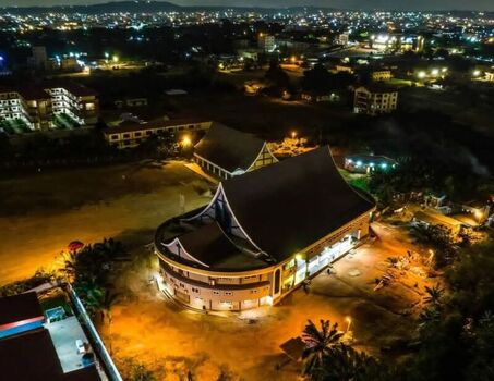 Aerial view of an illuminated church building at night surrounded by urban landscape and street lights in Ghana. Aerial view of an illuminated church building at night surrounded by urban landscape and street lights in Ghana.