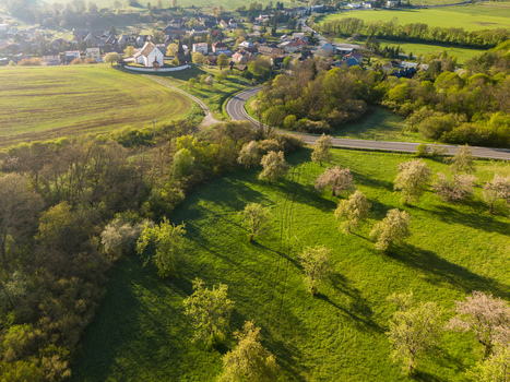 Aerial view of the historic Church of St. Martin surrounded by blooming trees and green meadows in the rural village of Cerin Banskobystricky kraj Slovakia. Aerial view of the historic Church of St. Martin surrounded by blooming trees and green meadows in the rural village of Cerin Banskobystricky kraj Slovakia.
