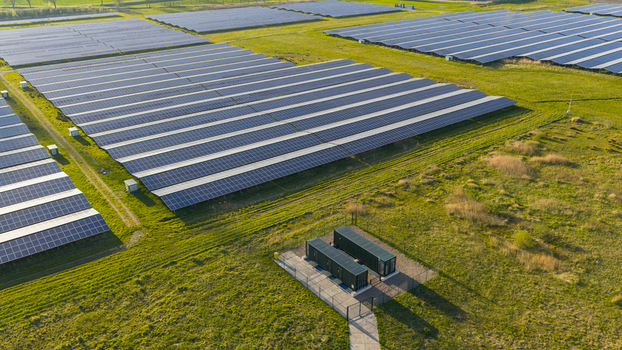 Aerial view of a large solar farm with rows of photovoltaic panels on green fields under bright sunlight in Farmsum Groningen Netherlands.