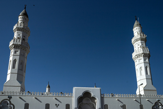 View of the white minarets of Masjid Quba against a clear blue sky in Madinah Al Madinah Province Saudi Arabia.
