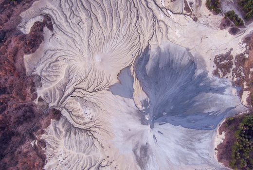 Aerial view of Vulcanii Noroiosi Paclele Mari showing the unique mud formations intricate drainage patterns and grey volcanic soil in Paclele Buzau County Romania.