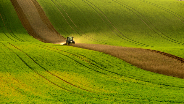 View of a tractor plowing a field in the rolling landscape of Moravia in Brno City District South Moravian Region Czechia.