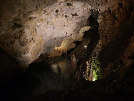 View of the interior of Vrelo Cave featuring intricate stalactites stalagmites and a calm underground lake in Matka Komuna e Sopishtes North Macedonia.