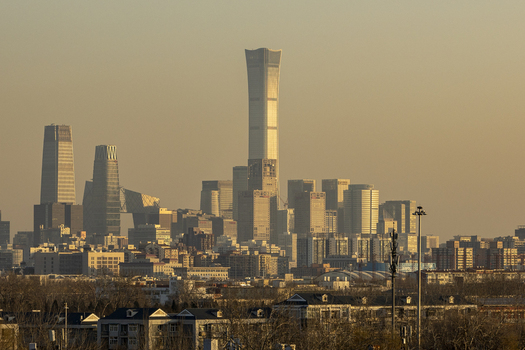 View of the modern skyline featuring the China Zun skyscraper and CCTV Headquarters under a golden sunset haze in Beijing Beijing China. View of the modern skyline featuring the China Zun skyscraper and CCTV Headquarters under a golden sunset haze in Beijing Beijing China.