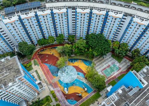 Aerial view of the Boon Keng residential complex featuring curved blue apartment blocks a central courtyard with a playground and lush greenery in Singapore Bendemeer Road Singapore. Aerial view of the Boon Keng residential complex featuring curved blue apartment blocks a central courtyard with a playground and lush greenery in Singapore Bendemeer Road Singapore.