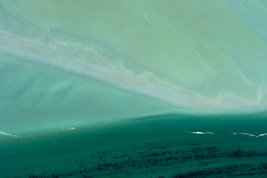 Aerial view of the turquoise ocean patterns and sandbanks of Shark Bay showcasing the vibrant contrast between shallow waters and deep channels in Shire of Shark Bay Western Australia Australia. Aerial view of the turquoise ocean patterns and sandbanks of Shark Bay showcasing the vibrant contrast between shallow waters and deep channels in Shire of Shark Bay Western Australia Australia.