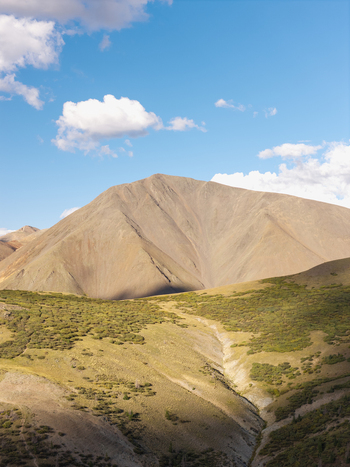 Aerial view of San Luis Peak with its rocky slopes and alpine vegetation under a blue sky in Gunnison Colorado United States.