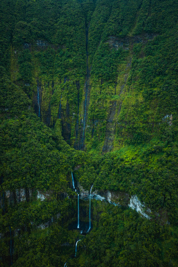 Aerial view of majestic waterfalls cascading down lush green tropical cliffs La Reunion France. Aerial view of majestic waterfalls cascading down lush green tropical cliffs La Reunion France.