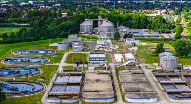 Aerial view of a wastewater treatment plant with circular sedimentation tanks and rectangular aeration basins in Cuxhaven Niedersachsen Germany.