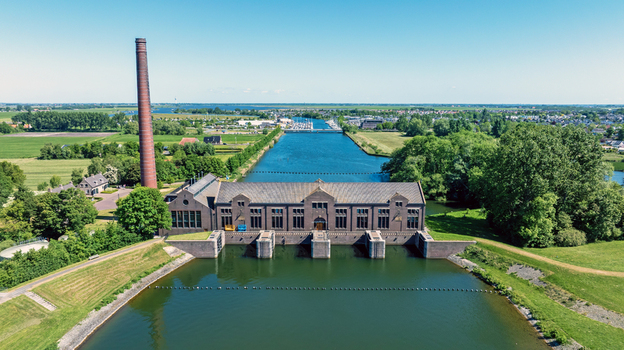 Aerial view of Wouda pumping station a historic UNESCO site with its brick architecture tall chimney and surrounding canal system in Lemmer Friesland Netherlands.