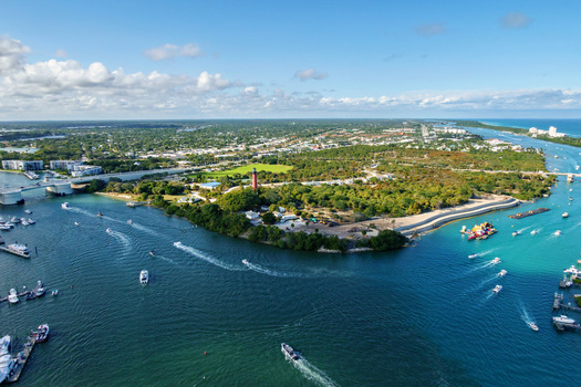 Aerial view of the Jupiter Inlet Lighthouse standing tall amidst the vibrant turquoise waters and lush greenery a picturesque scene of Florida s coastal beauty Jupiter Florida United States.