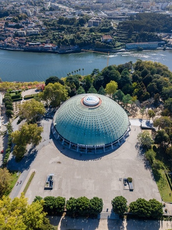 Aerial view of Pavilhao Rosa Mota also known as Super Bock Arena featuring its distinctive green dome surrounded by lush gardens and the Douro River in Porto Porto Portugal. Aerial view of Pavilhao Rosa Mota also known as Super Bock Arena featuring its distinctive green dome surrounded by lush gardens and the Douro River in Porto Porto Portugal.