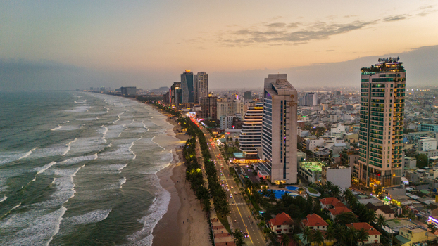 Aerial view of the coastal skyline of Da Nang with modern high rise hotels a sandy beach and a road running along the shoreline at sunset in Da Nang Vietnam. Aerial view of the coastal skyline of Da Nang with modern high rise hotels a sandy beach and a road running along the shoreline at sunset in Da Nang Vietnam.