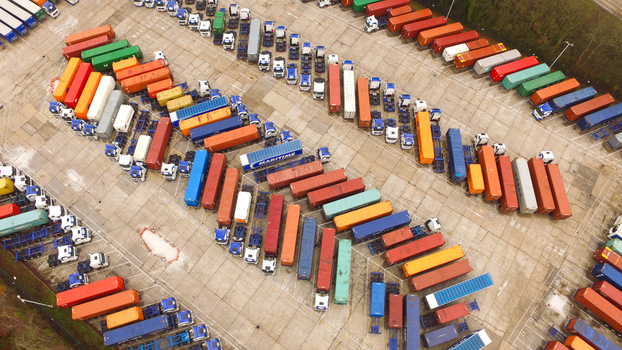 Aerial view of a busy truck parking lot filled with colorful shipping containers arranged in rows at a logistics facility in Southampton England United Kingdom.