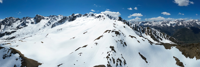 Aerial view of the snow covered peaks of Pointe Ronde with rocky ridges under a clear blue sky in Trient Valais Switzerland.