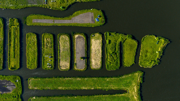 Aerial view of the unique island landscape of Oosterdel nature reserve with narrow water channels in Broek op Langedijk Noord Holland Netherlands. Aerial view of the unique island landscape of Oosterdel nature reserve with narrow water channels in Broek op Langedijk Noord Holland Netherlands.