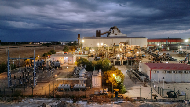 Aerial view of an industrial recycling facility with metal scrap piles and an adjacent power substation under a dramatic cloudy evening sky in Sremska Mitrovica Vojvodina Serbia. Aerial view of an industrial recycling facility with metal scrap piles and an adjacent power substation under a dramatic cloudy evening sky in Sremska Mitrovica Vojvodina Serbia.