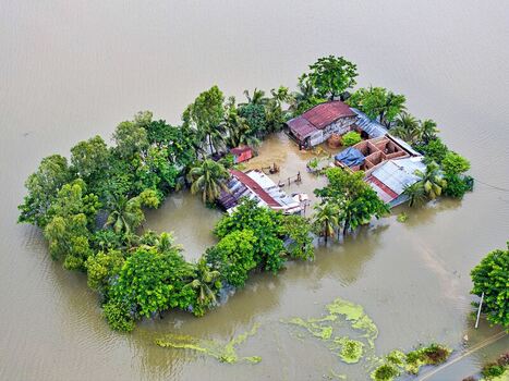 Banshkhali Upazila Chittagong Division Bangladesh 10 July 2026 Aerial view of a homestead isolated by severe floodwaters with submerged vegetation and damaged structures. Banshkhali Upazila Chittagong Division Bangladesh 10 July 2026 Aerial view of a homestead isolated by severe floodwaters with submerged vegetation and damaged structures.