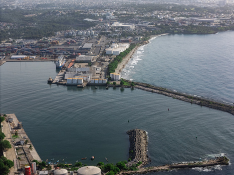 Aerial view of the industrial port of Bajos de Haina with storage tanks shipping containers and a breakwater in the Caribbean Sea in Bajos de Haina San Cristobal Province Dominican Republic.
