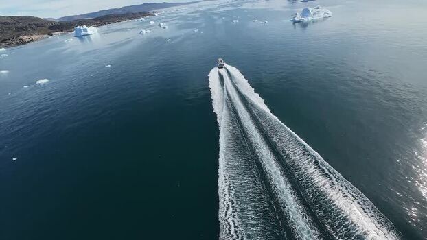 FPV aerial view of boat moving through icy waters in Greenland. FPV aerial view of boat moving through icy waters in Greenland.