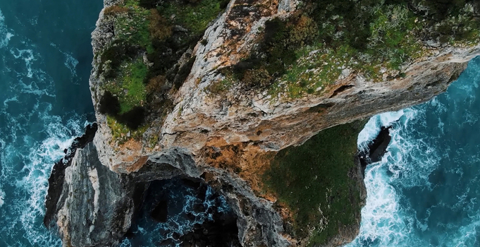 Aerial view of the rugged rocky cliffs and crashing waves at Ursa Beach in Colares Portugal. Aerial view of the rugged rocky cliffs and crashing waves at Ursa Beach in Colares Portugal.
