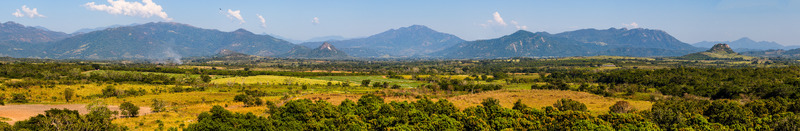 Aerial view of Cerro de San Juan mountain range overlooking a vast valley with green agricultural fields and dense trees in Tequesquite Jalisco Mexico.