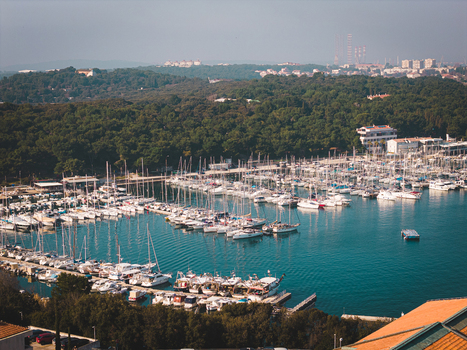Aerial view of boats and yachts resting in the marina amidst the backdrop of lush green forests Pula Istria County Croatia.