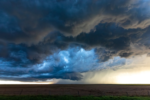 View of a dramatic supercell storm with dark swirling clouds and heavy rain over a vast agricultural field in Oklahoma City Oklahoma United States.