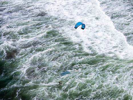 Aerial view of a kitesurfer riding waves at Depok Beach in the Special Region of Yogyakarta Indonesia. Aerial view of a kitesurfer riding waves at Depok Beach in the Special Region of Yogyakarta Indonesia.