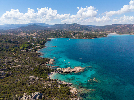 Aerial view of the turquoise waters and rocky coastline of San Teodoro with Mediterranean vegetation and small boats in the bay San Teodoro Sardegna Italy.