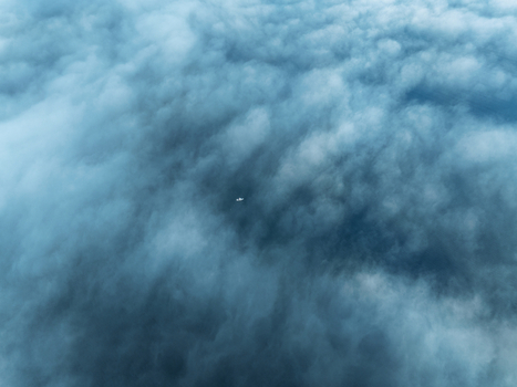 Aerial view of a small boat visible through a dense layer of clouds above Lake Zurich Zurich Zurich Switzerland.