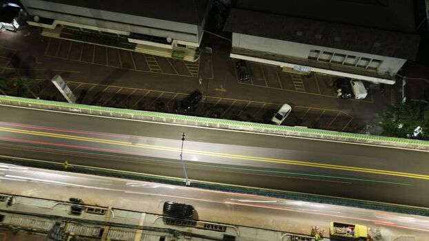 Aerial view of a highway at night with light trails from moving vehicles adjacent parking lot with parked cars and urban infrastructure in South Jakarta Jakarta Indonesia. Aerial view of a highway at night with light trails from moving vehicles adjacent parking lot with parked cars and urban infrastructure in South Jakarta Jakarta Indonesia.