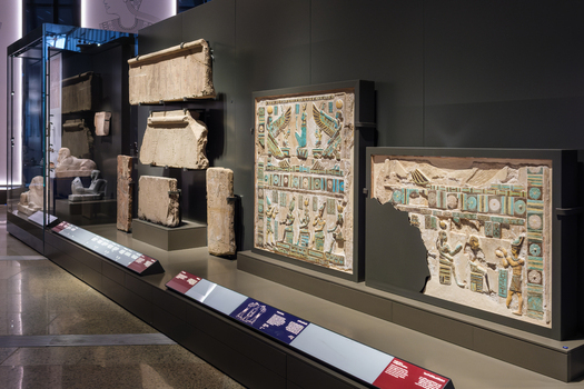 Giza Egypt 16 May 2026 View of Grand Egyptian Museum featuring ancient stone reliefs with intricate carvings and turquoise pigments on display in a modern gallery.