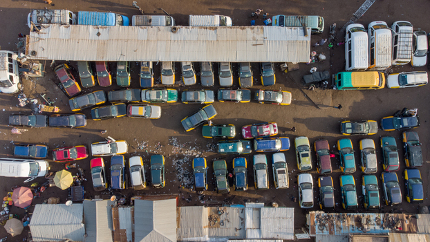 Tamale Ghana 16 March 2023 Aerial view of the Tamale Interchange showing rows of parked vehicles taxis and vans arranged in a busy transport hub with corrugated metal roofs.