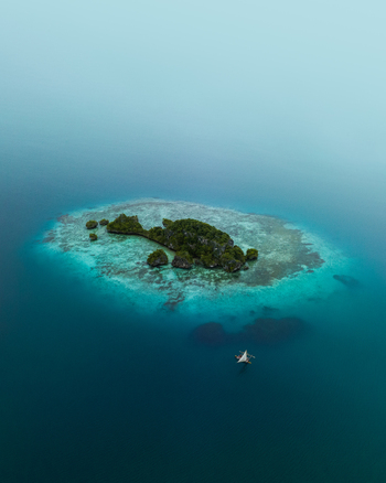 Aerial view of an island s vibrant green vegetation contrasts against the surrounding turquoise and deep blue waters Pine Island L Île des Pins New Caledonia. Aerial view of an island s vibrant green vegetation contrasts against the surrounding turquoise and deep blue waters Pine Island L Île des Pins New Caledonia.