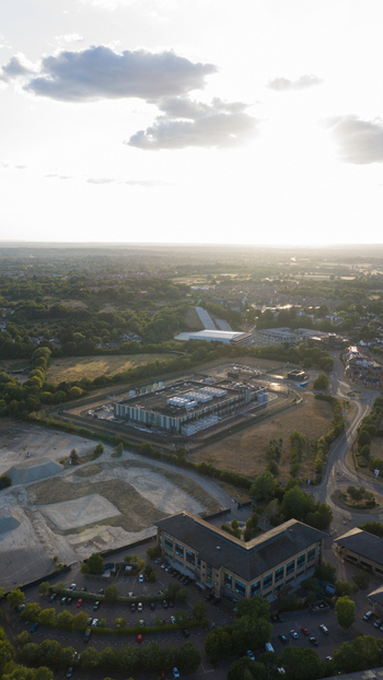 Aerial view of a data center facility surrounded by suburban greenery parking lots and roads in Bracknell England United Kingdom.