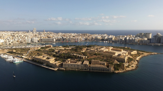 Aerial view of Manoel Island and historic Fort Manoel surrounded by the blue waters of Marsamxett Harbour with the Valletta skyline in Valletta Port Region Malta. Aerial view of Manoel Island and historic Fort Manoel surrounded by the blue waters of Marsamxett Harbour with the Valletta skyline in Valletta Port Region Malta.