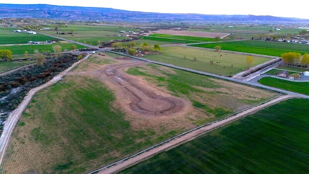 Aerial view of green agricultural fields and a new dirt road construction site under a clear sky Loma Colorado United States. Aerial view of green agricultural fields and a new dirt road construction site under a clear sky Loma Colorado United States.