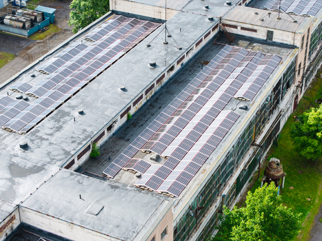 Aerial view of an industrial building rooftop covered with rows of solar panels in Olaine Olaine Municipality Latvia. Aerial view of an industrial building rooftop covered with rows of solar panels in Olaine Olaine Municipality Latvia.