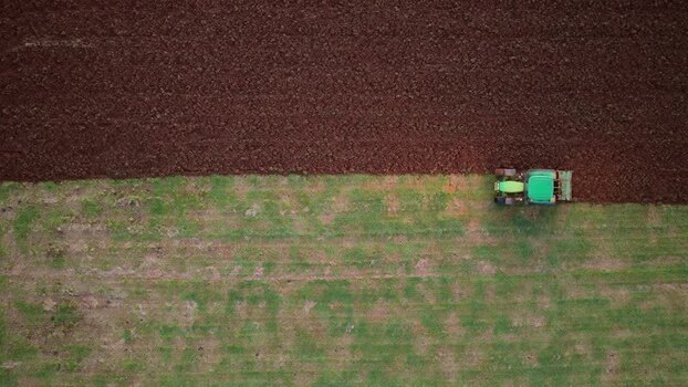 Aerial view of tractor plowing field in Terceira Portugal.